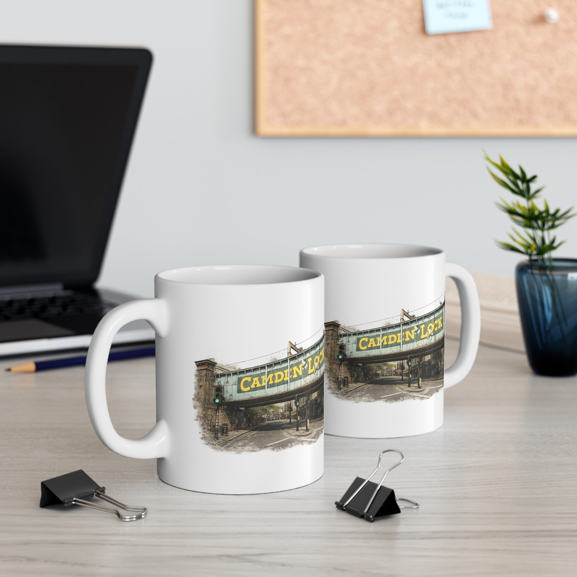 Two mugs with a Camden Lock design on a desk with office supplies and a plant.
