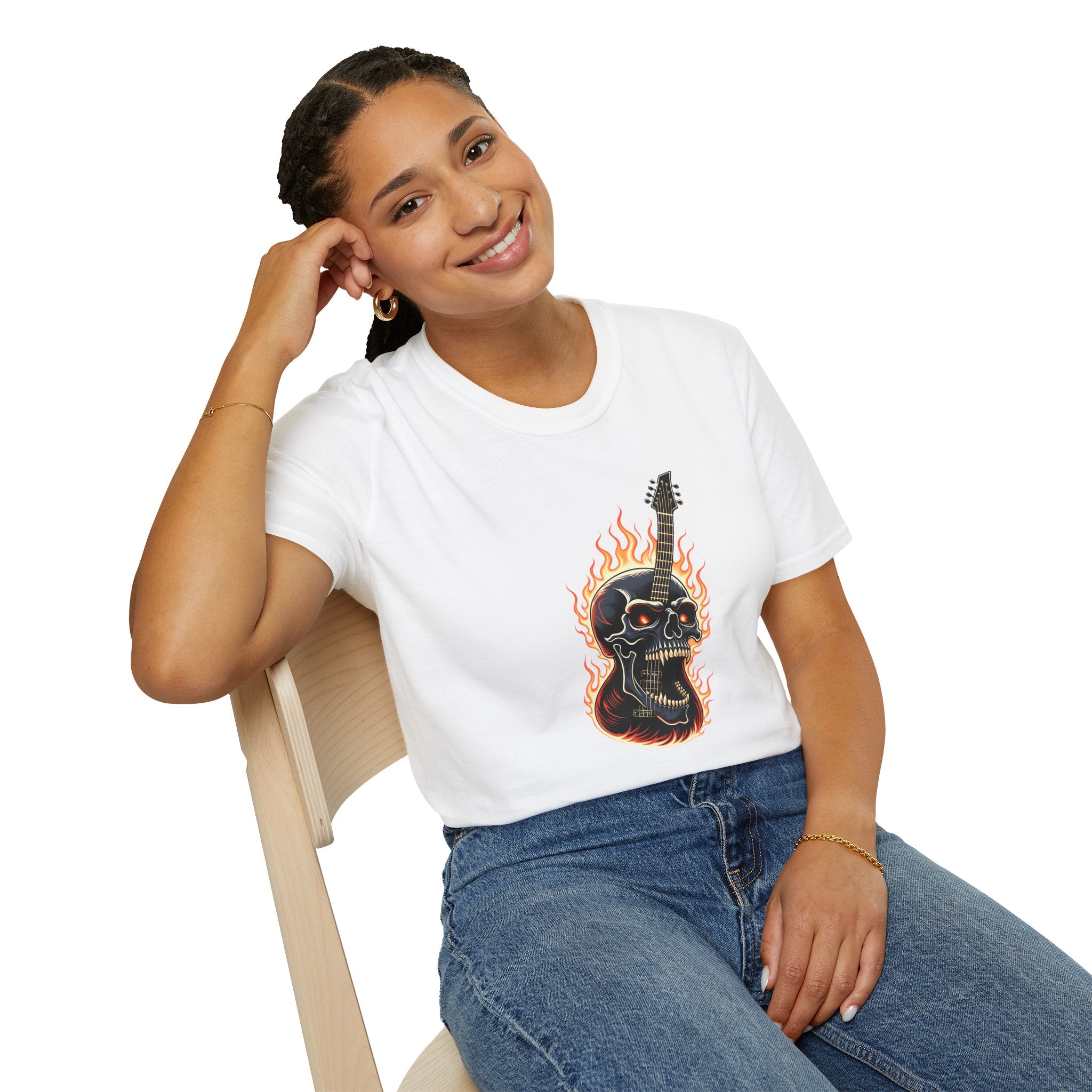 Person wearing a white t-shirt with a graphic design of a  flaming skull and guitar, sitting on a chair.