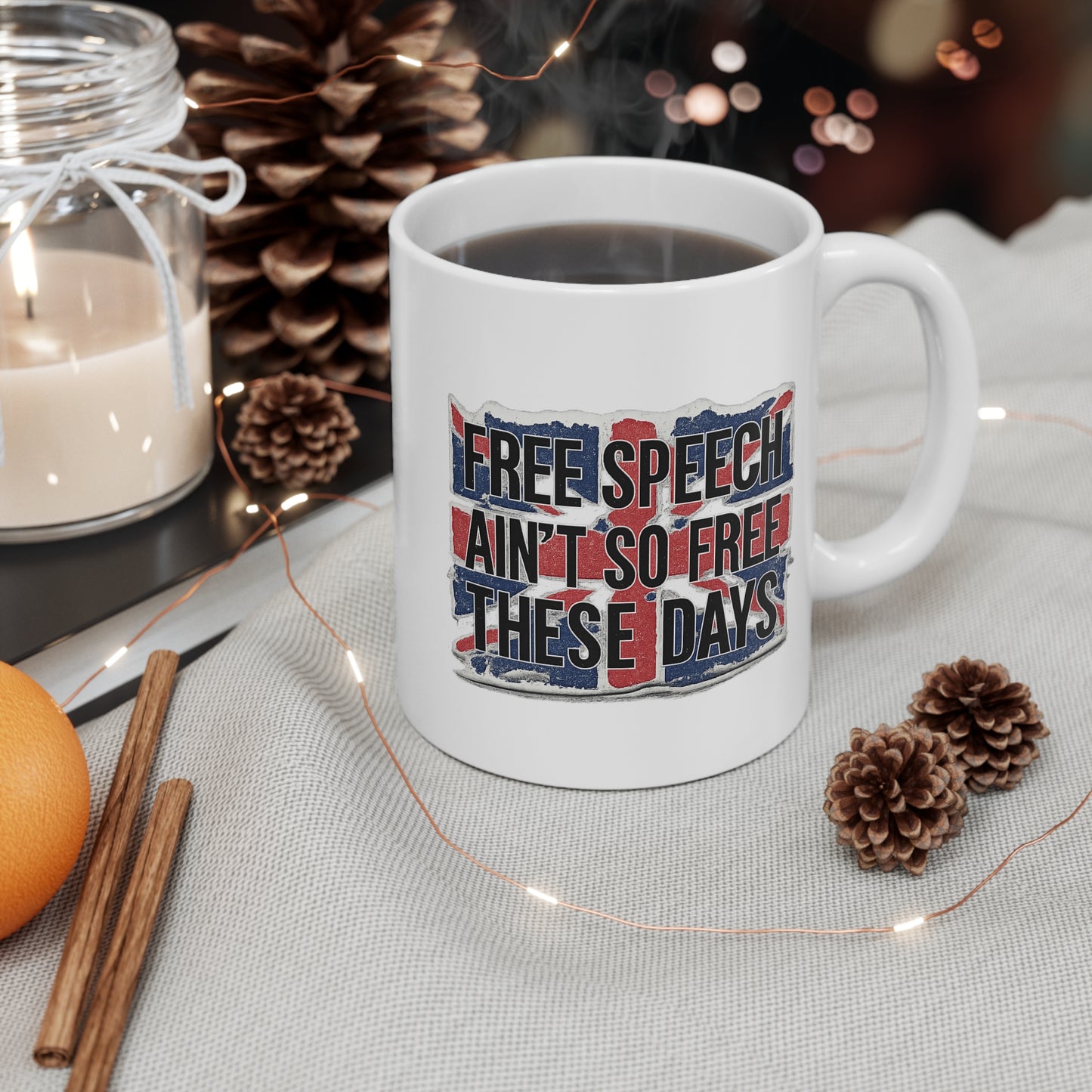 White mug with 'Free speech ain't so free these days' text, surrounded by decorative items on a table.