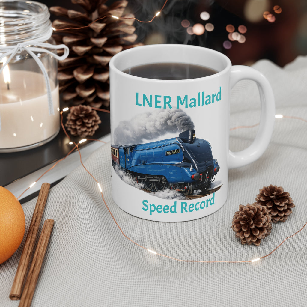 Mug with LNER Mallard design featuring a blue steam train, surrounded by decorative items on a table.
