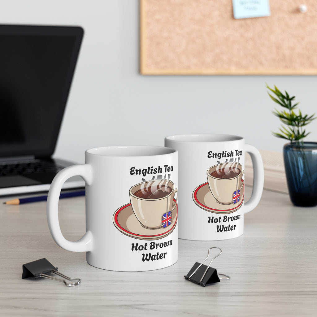 Two mugs with a humorous design of a teacup and text on a desk with office supplies.