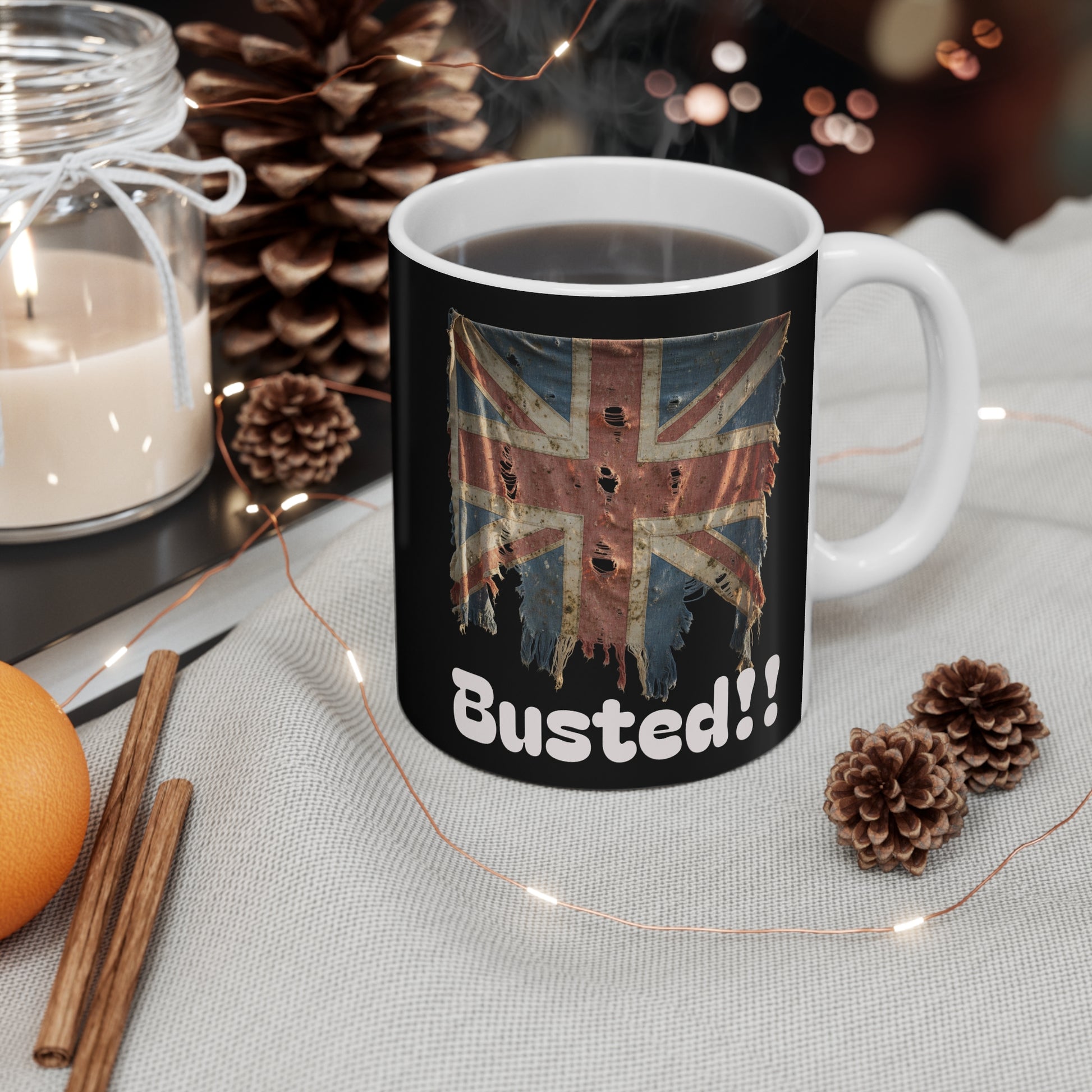 Mug with British flag design and 'Busted!!' text on a table with decorative items.