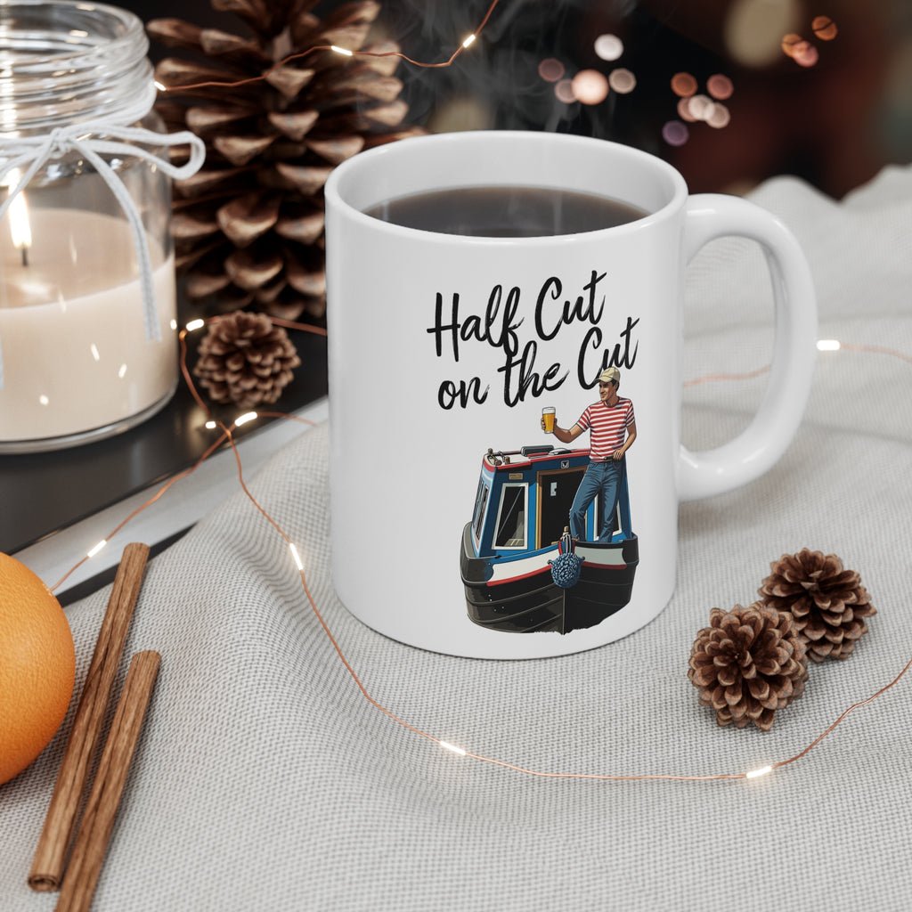 White mug with a design and text, surrounded by decorative items on a table.