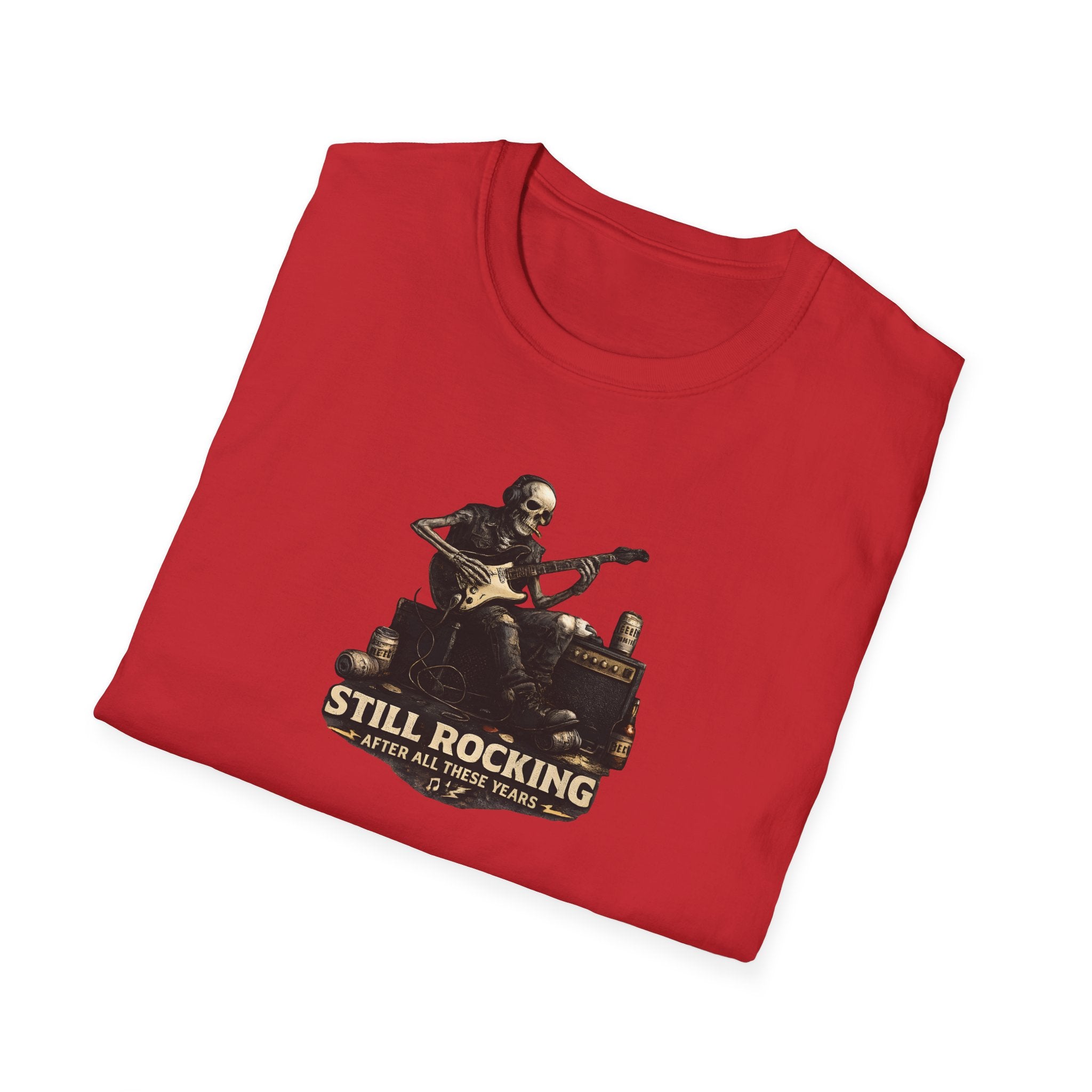 Folded red t-shirt with a graphic of a skeleton playing guitar and the text 'Still Rocking After All These Years' on a white background.