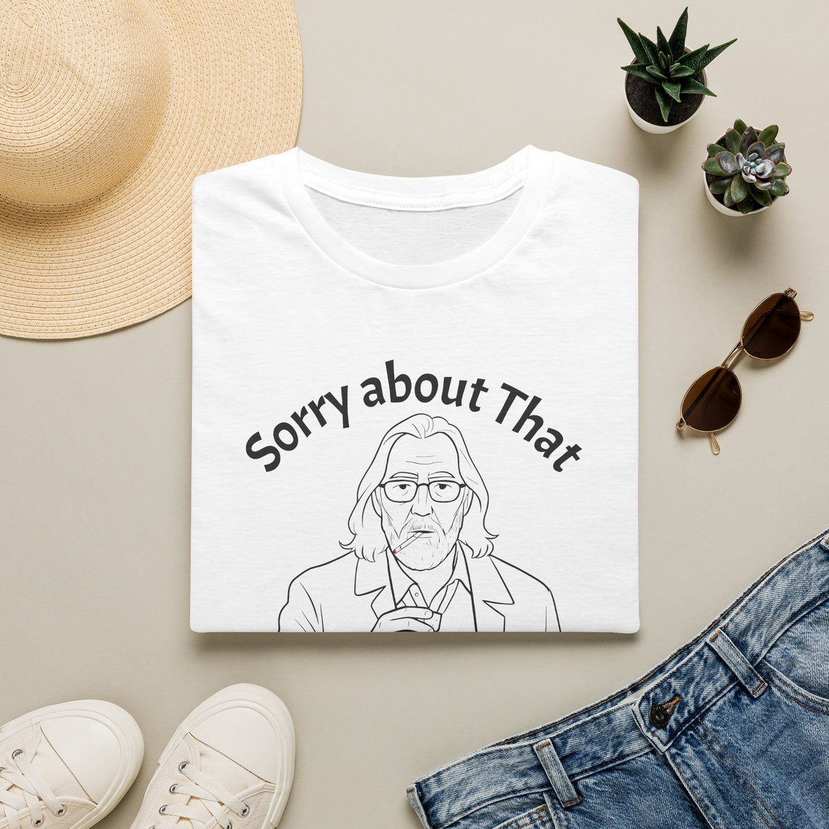 White t-shirt with a slow horses tv show graphic and text, surrounded by a sun hat, sunglasses, sneakers, and jeans on a light background.