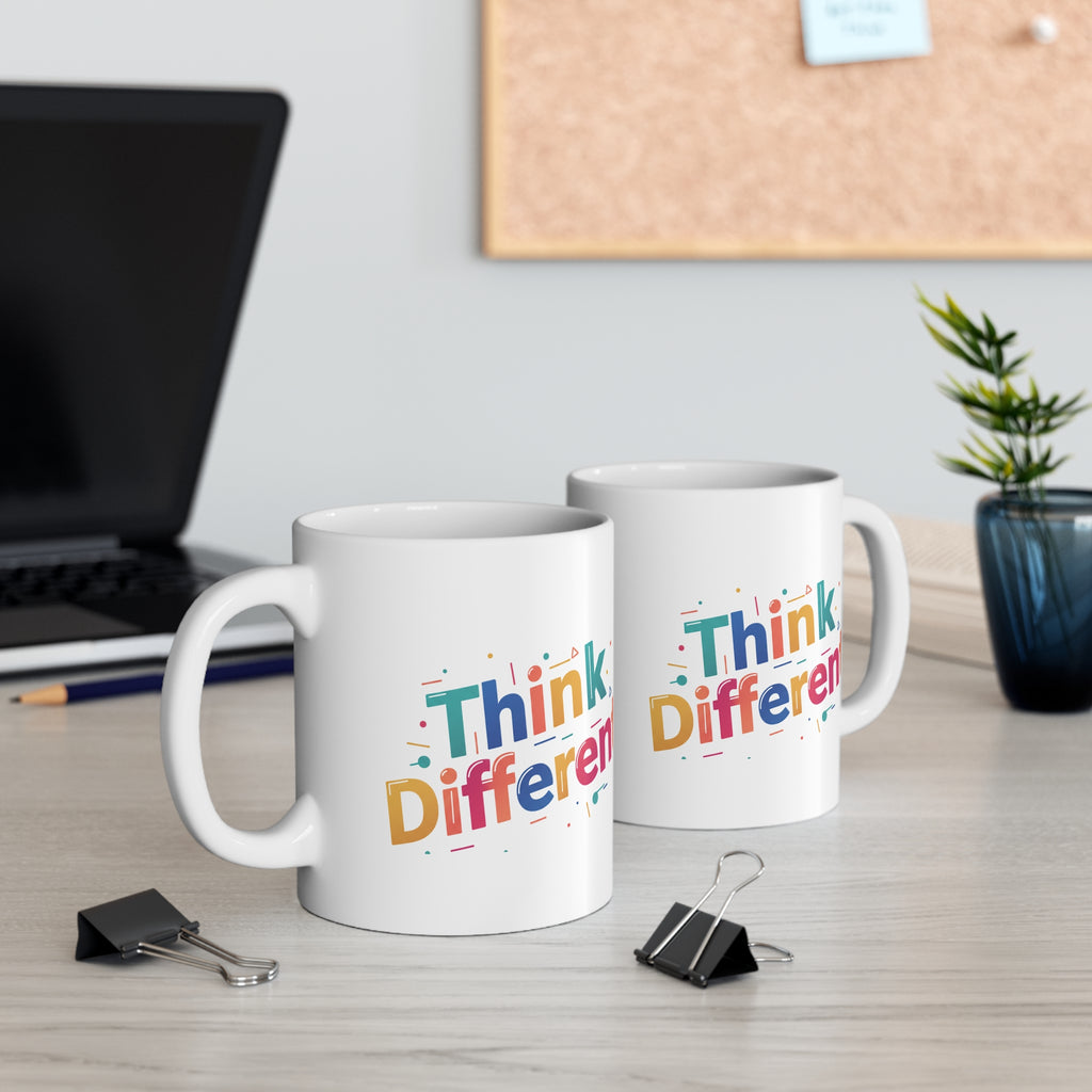 Two white mugs with 'Think Different' text on a desk with office supplies.