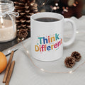 White mug with 'Think Different' text on a table with decorative items