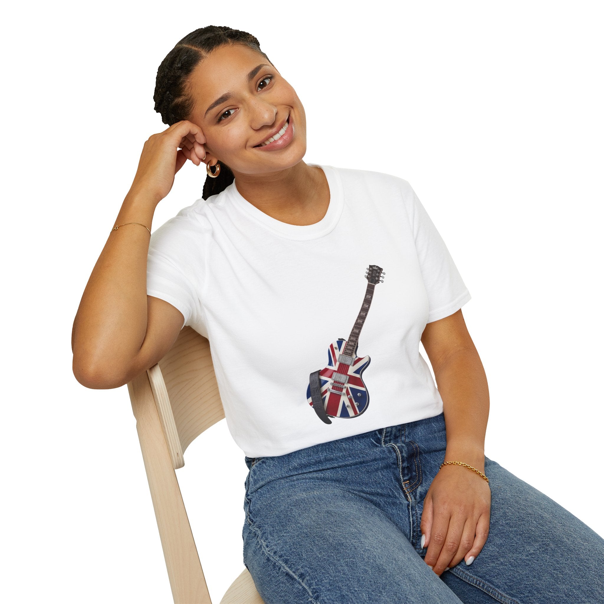Person wearing a white t-shirt with a guitar and Union Jack design, sitting on a chair.