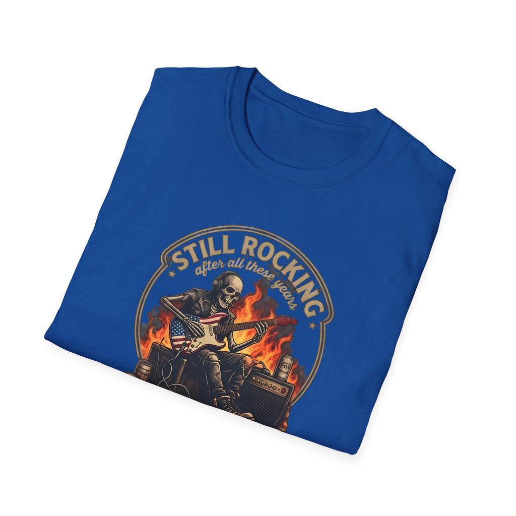 Folded blue t-shirt with a graphic design of a skeleton playing guitar and text 'Still Rocking after all these years' on a white background.