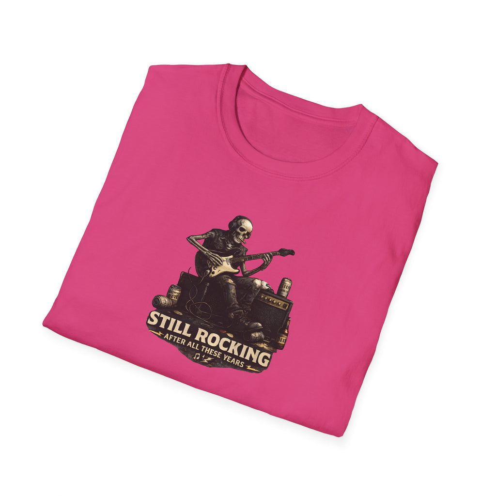 Pink t-shirt with a graphic of a skeleton playing guitar and text 'Still Rocking After All These Years' on a white background.
