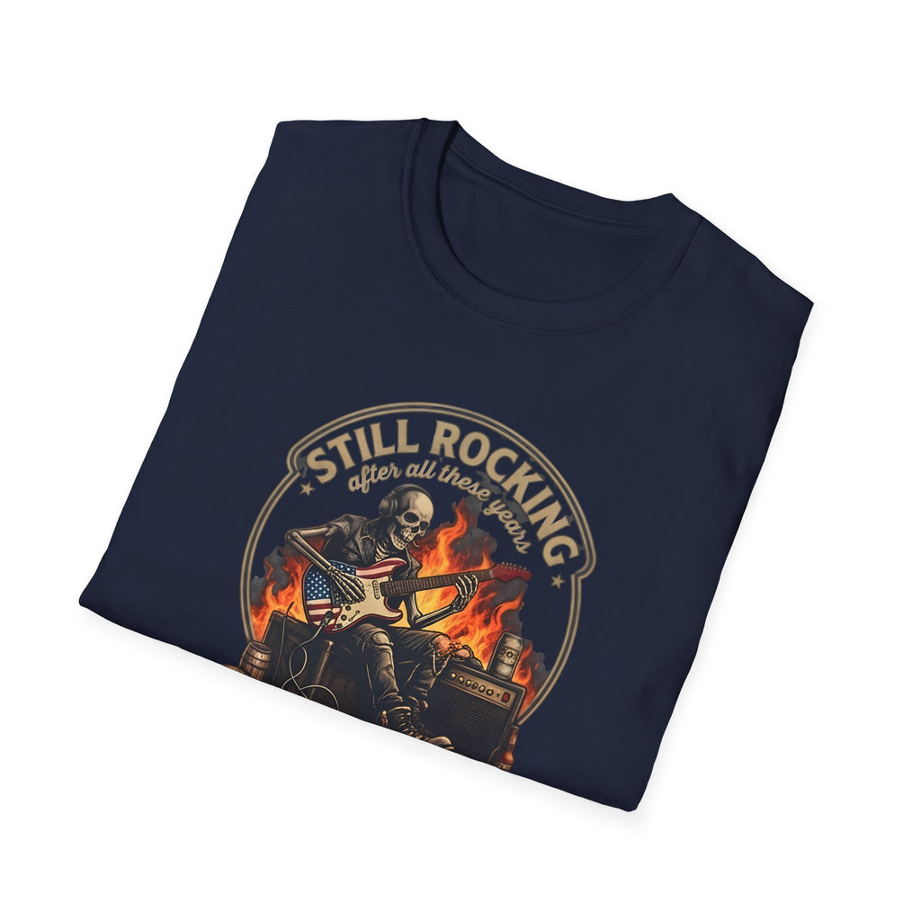 Folded navy blue t-shirt with a graphic design of a skeleton playing guitar and text 'Still Rocking after all these years' on a white background.