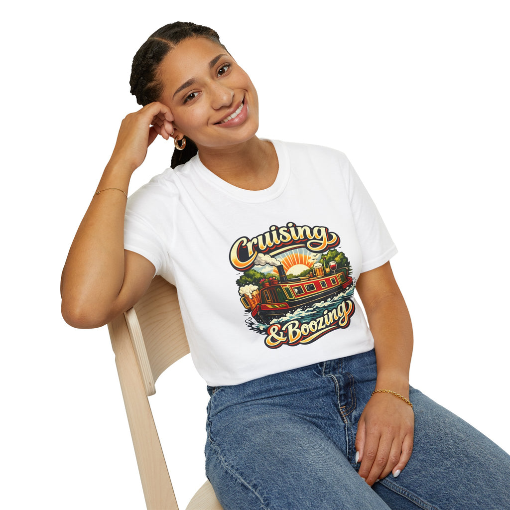 Person wearing a white t-shirt with 'Cruising & Boozing' design, sitting on a chair.