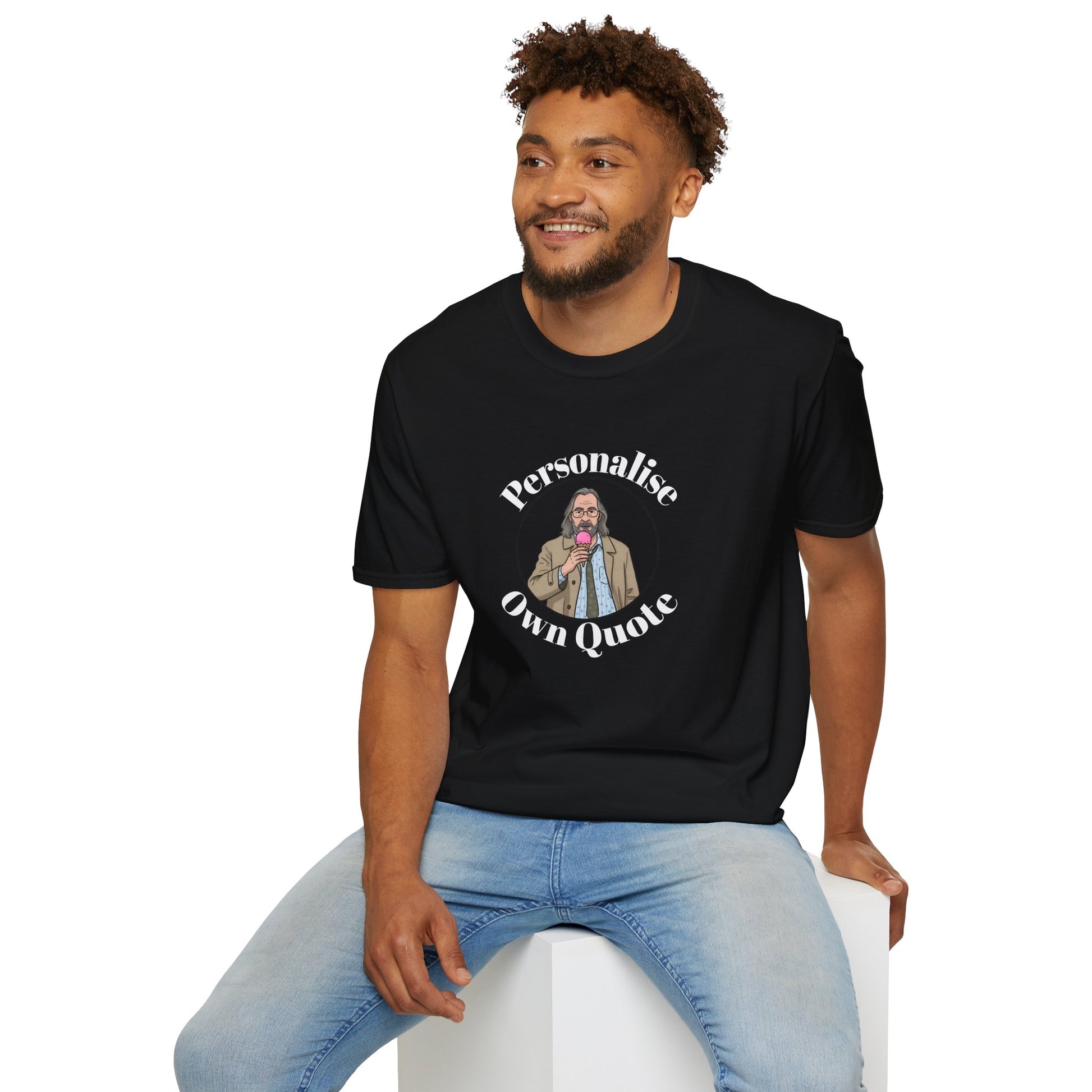 Man wearing a black Jackson lamb  t-shirt with a graphic and text, sitting on a white stool against a white background.
