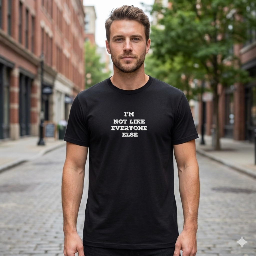 Man wearing a black t-shirt with 'I'm not like everyone else' text on a city street.