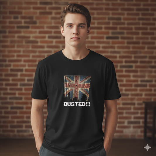 Person wearing a black t-shirt with a Union Jack design and 'BUSTED!!' text against a brick wall.