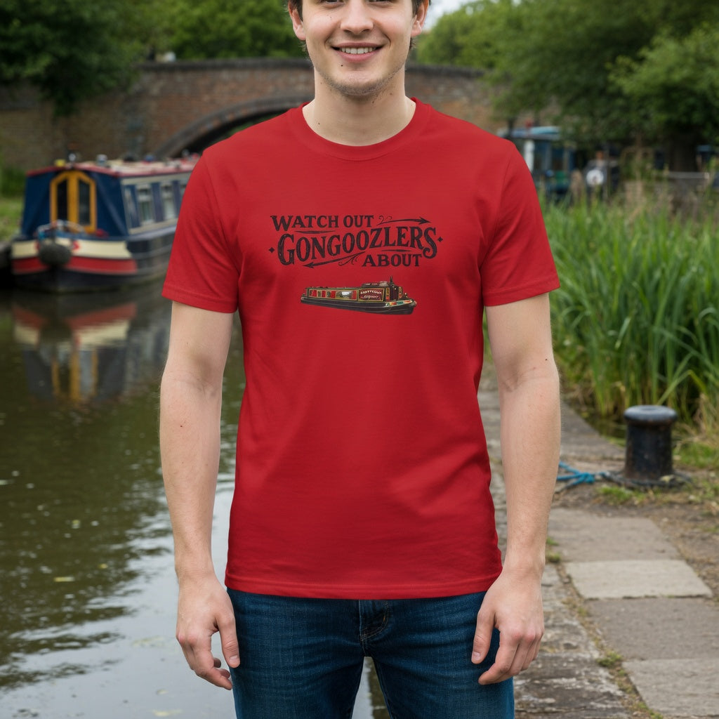 Person wearing a red t-shirt with text  Gongoozlers graphic, standing by a canal with boats and greenery.