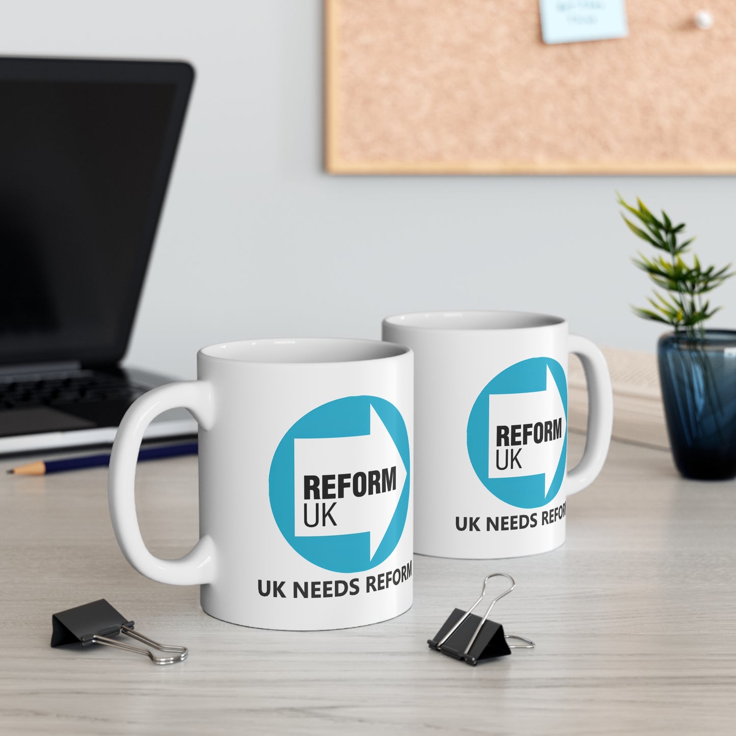 Two white mugs with 'REFORM UK' logo on a desk with office items.
