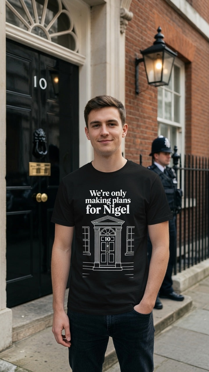 A man wearing a black graphic t-shirt stands in front of Downing Street (Number 10) in London. The t-shirt features a white graphic of the Downing Street front door  House with the text 'We're only making plans for Nigel'.